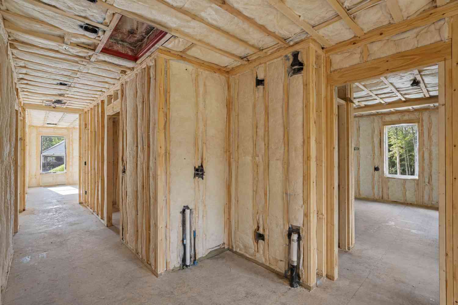 Framed house interior with spray foam insulation installed in walls and ceiling.