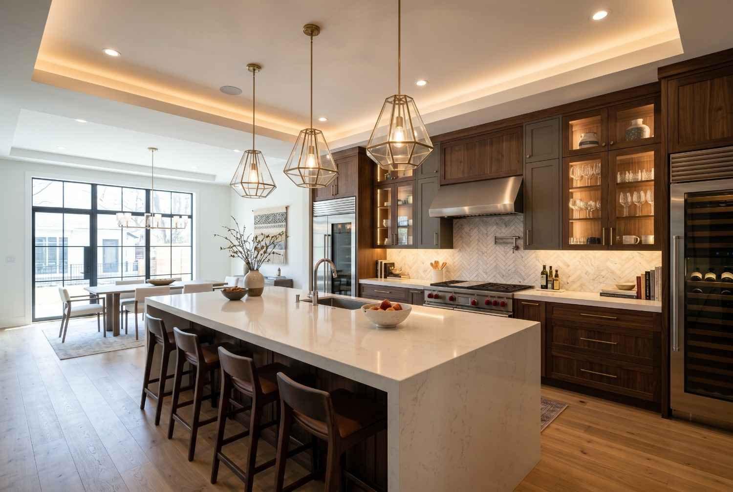 Modern luxury kitchen remodel featuring a large quartz waterfall island, custom dark wood cabinetry, premium stainless steel appliances, designer pendant lighting, and open-concept dining area. High-end kitchen renovation with elegant finishes, spacious layout, and contemporary interior design.