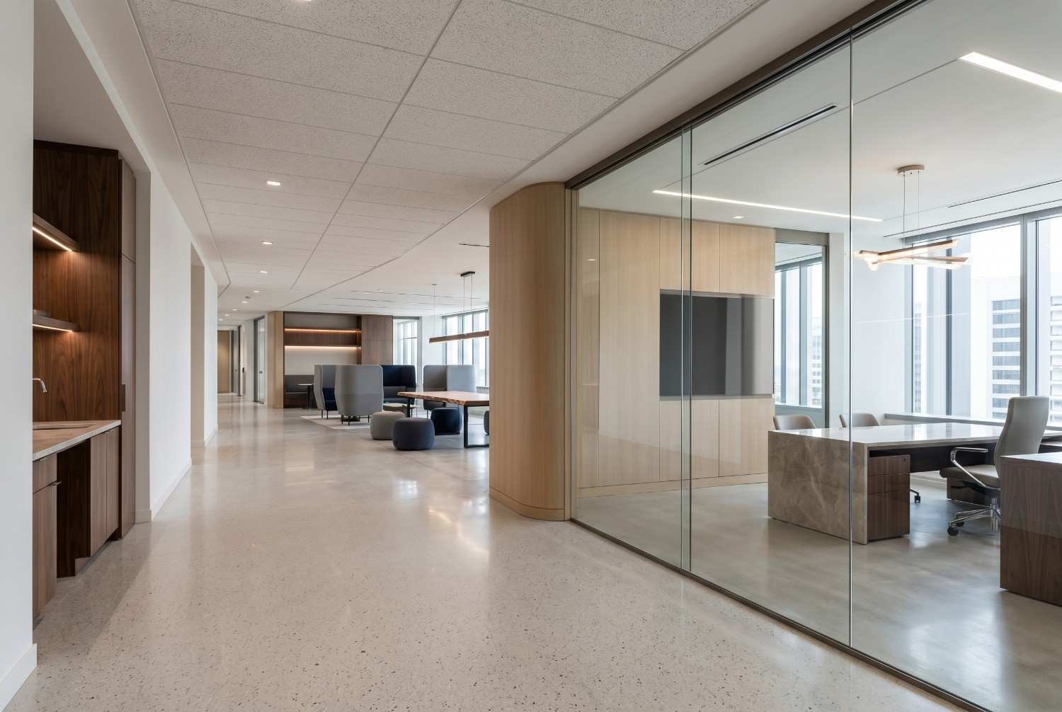 Modern office interior with glass conference room, open workspace layout, polished concrete flooring, contemporary furnishings, and floor-to-ceiling windows. Professional corporate environment showcasing modern office design, collaborative workspaces, executive meeting areas, and premium commercial architecture.