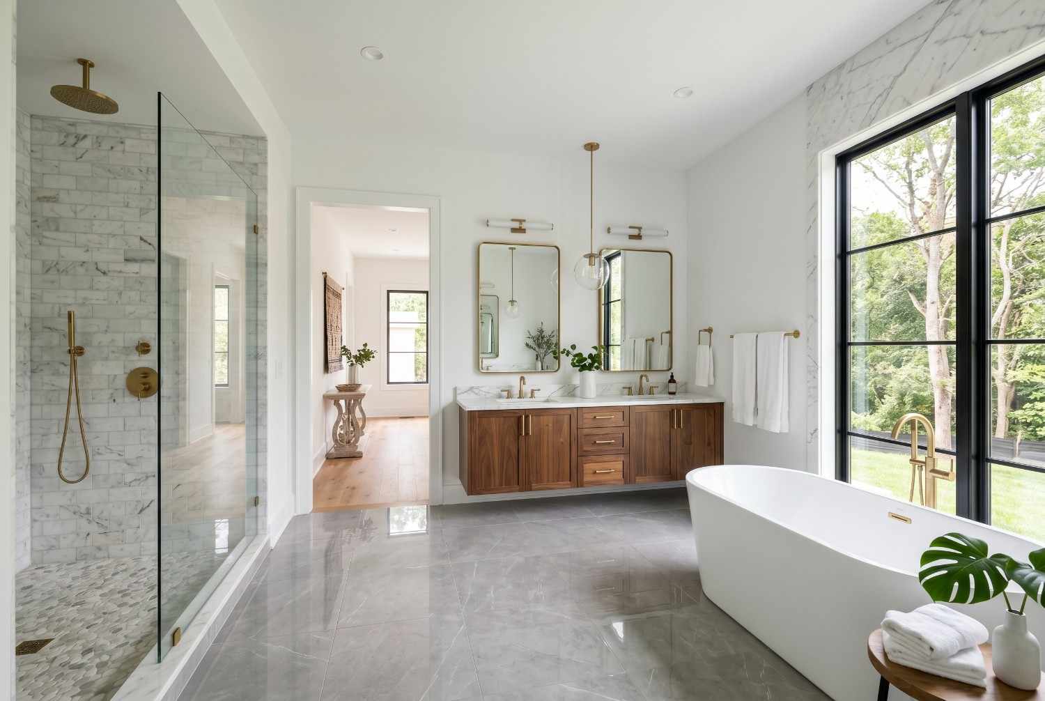 Luxury spa-style bathroom with freestanding soaking tub, walk-in marble shower, double vanity, and large picture window. Modern bathroom design featuring premium fixtures, natural light, elegant finishes, and high-end residential interior remodeling.