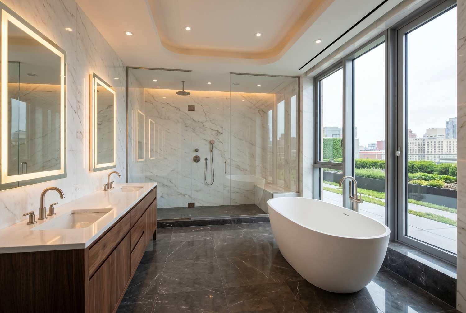 Luxury modern bathroom with freestanding soaking tub, walk-in marble shower, double vanity, and floor-to-ceiling windows. Spa-inspired bathroom design featuring illuminated mirrors, premium stone finishes, natural light, and high-end residential interior remodeling with city views.