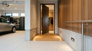 Modern home entryway connecting an organized garage to a warm wood-paneled hallway with recessed wall step lighting
