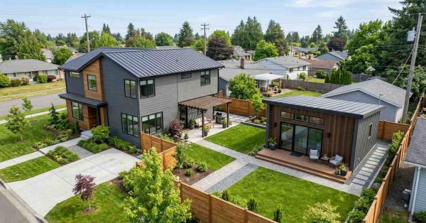 Modern two-story home with a detached backyard ADU, landscaped yard, patio area, and fenced property viewed from above.