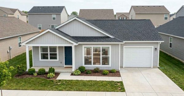 Modest newly built suburban home with practical design, standard finishes, attached garage, and efficient layout, representing the type of house that can realistically be constructed with a $200,000 building budget.