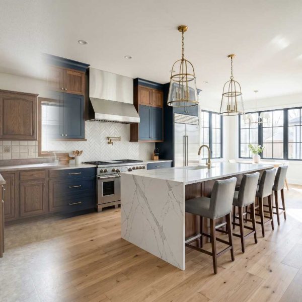 Kitchen remodel before-and-after transformation featuring an outdated kitchen upgraded to a luxury modern design. Contemporary kitchen renovation with a quartz waterfall island, custom navy cabinetry, hardwood flooring, designer lighting, and premium finishes showcasing high-end residential remodeling.